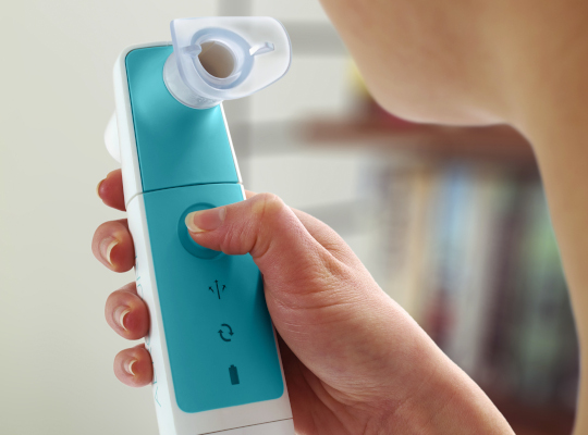 close up of person holding respiratory trainer