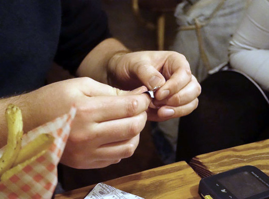 hands opening test strip at table