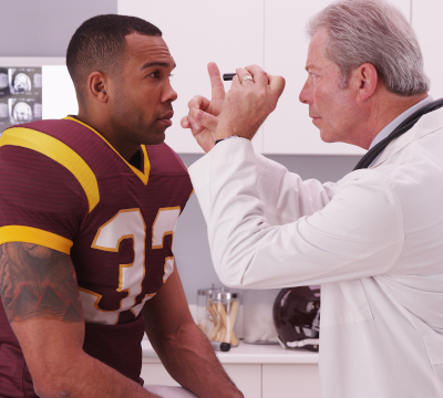 health care professional examining an american football player