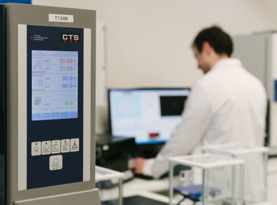 laboratory with test equipment and person in white coat in background