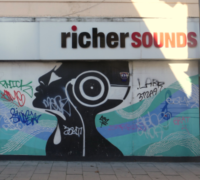 richer sounds store sign over mural of person listening to headphones