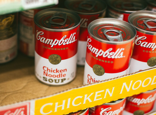 tins of chicken noodle soup on supermarket shelf