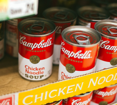 tins of chicken noodle soup on supermarket shelf