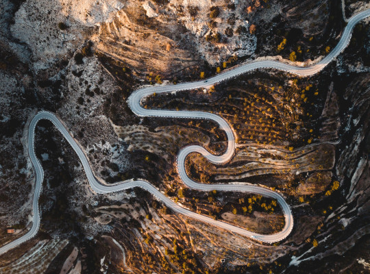 aerial view of road winding through rocky terrain