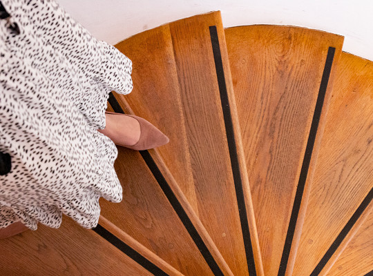 persons foot at edge of steep spiral staircase